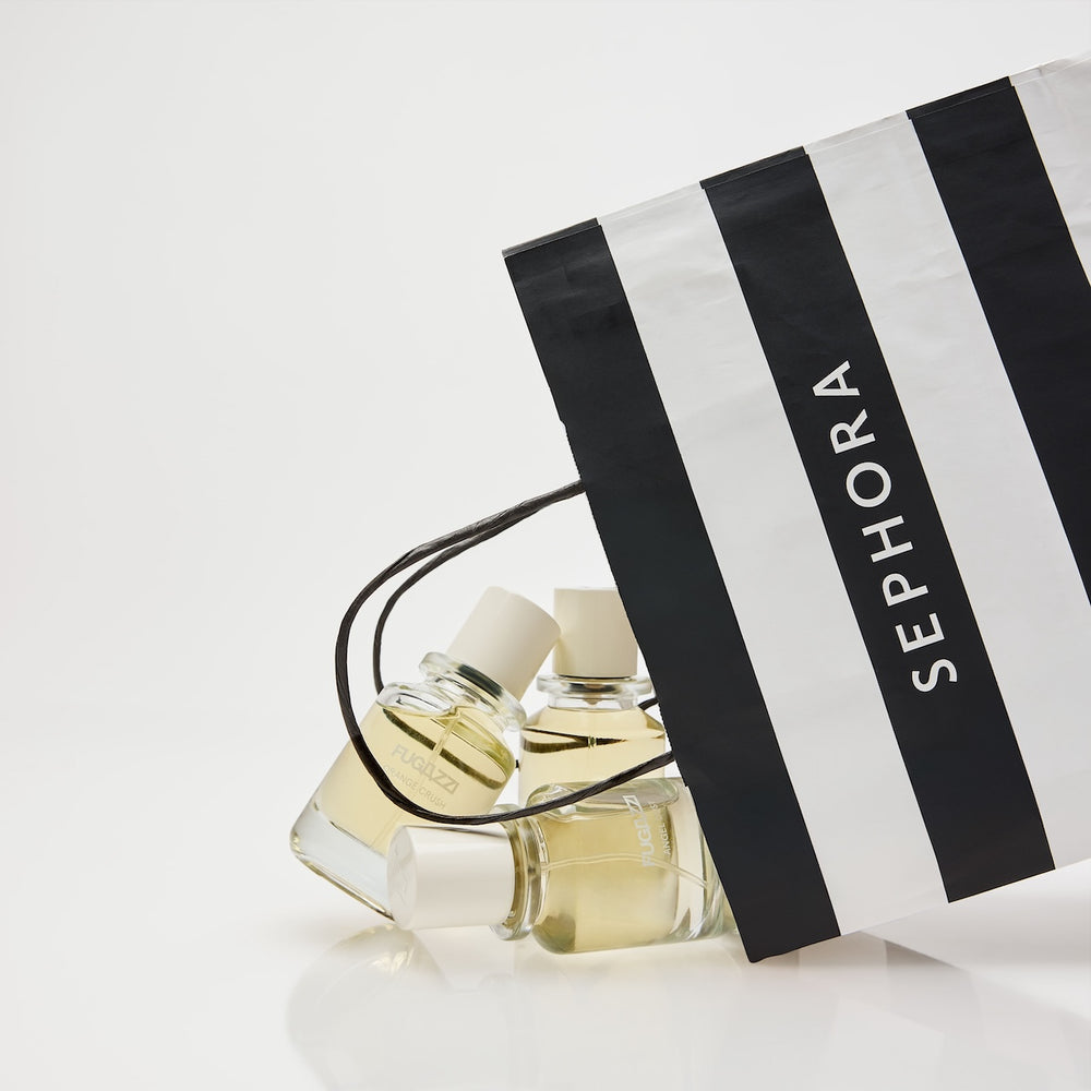 Fugazzi fragrance held against a dark suit