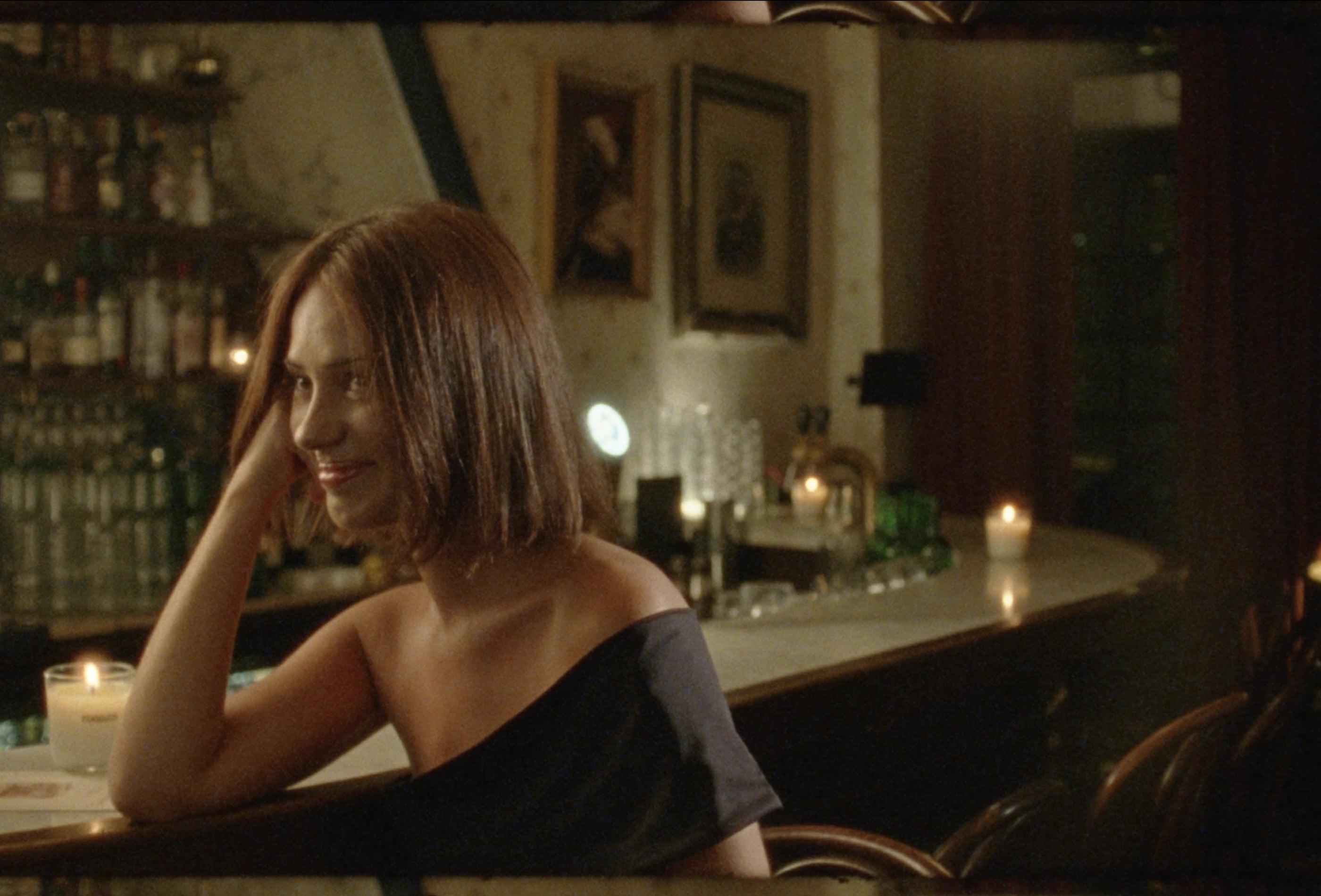 Woman sitting at a candlelit bar